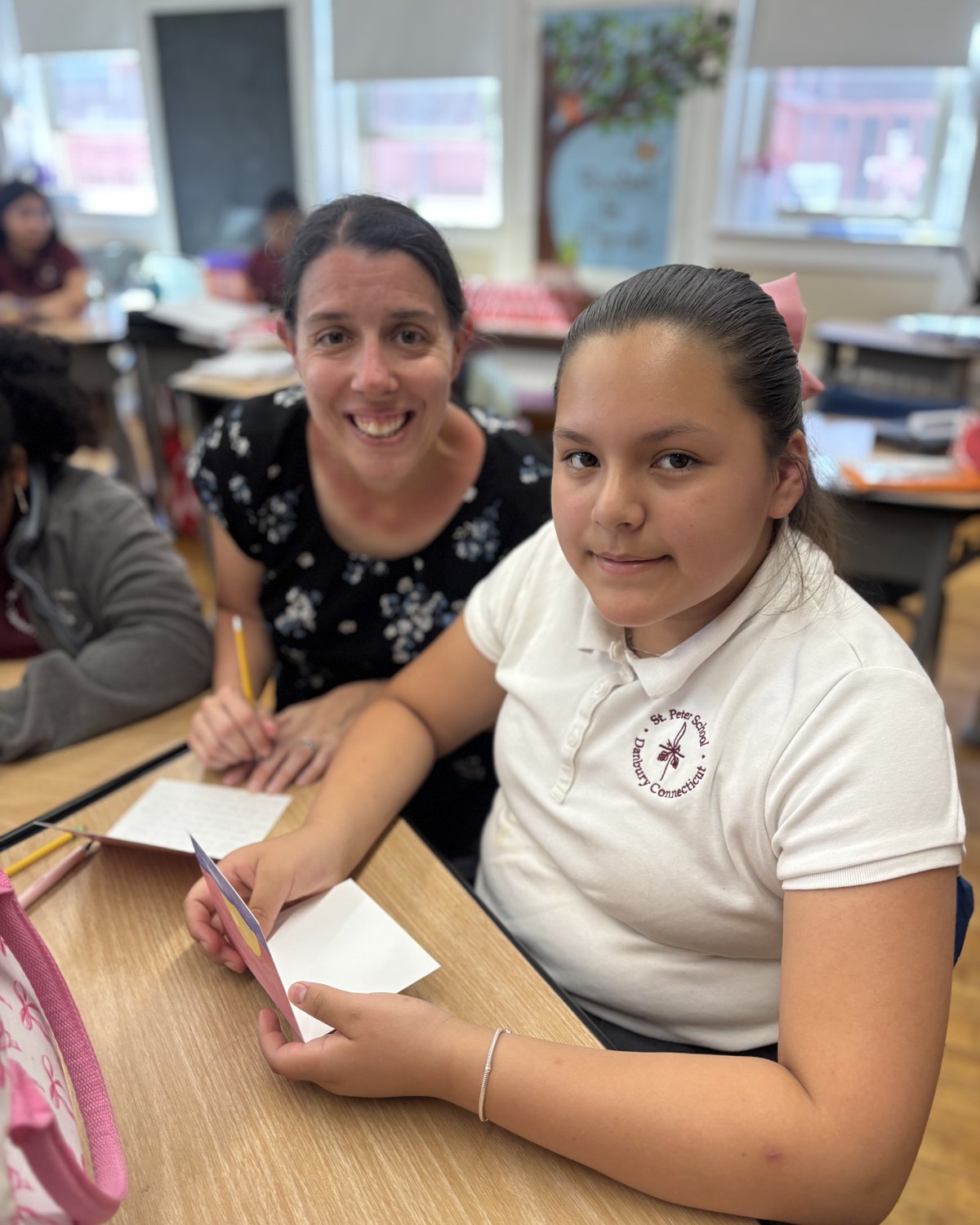A scholarship student with their teacher in a Catholic school classroom