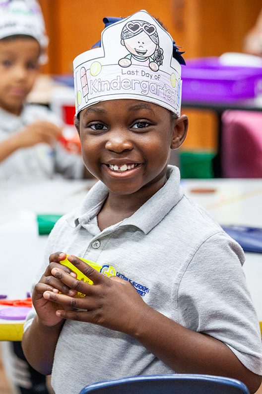 A scholarship student smiling in her Catholic school classroom
